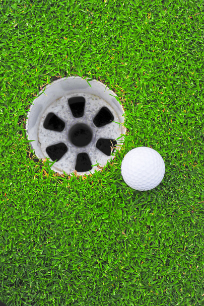 м'яч для гольфу та дірка для гольфу на зеленій траві
  - Фото, зображення