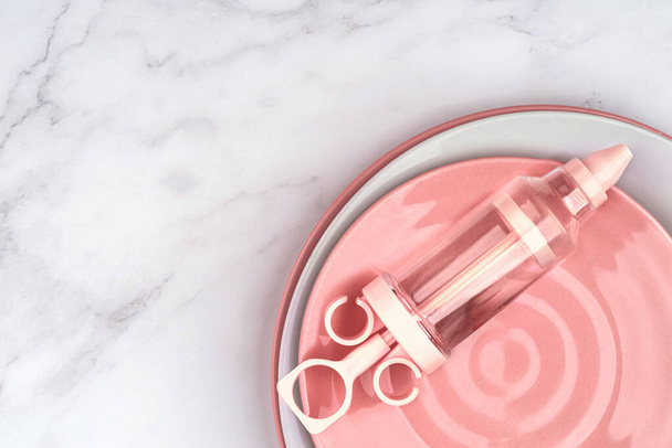 Saco de pastelaria creme injetor rosa para decoração de sobremesa de bolo, fornece kit de gelo pontas de bico de tubulação. Ferramentas DIY em fundo de mármore branco. Cozinhar conceito de padaria com espaço de cópia - Foto, Imagem