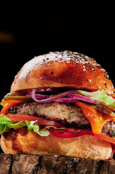 Hamburguesa de carne con queso, tomates, cebolla roja, pepino y lechuga Close up. Menú de hamburguesas. Espacio para el texto. Alimentos poco saludables. - Foto, Imagen