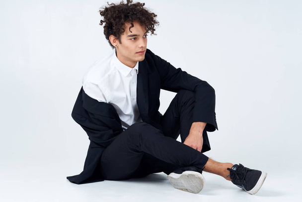 hombre guapo en traje sentado en el piso de la moda confianza luz fondo - Foto, Imagen