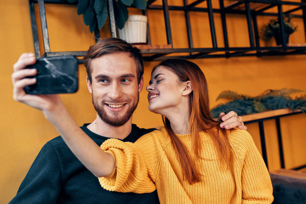 жінка з мобільним телефоном і щасливий чоловік друзі веселий інтер'єр сімейного спілкування
 - Фото, зображення