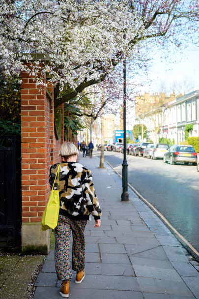 Οπίσθια όψη της όμορφης γυναίκας μιλάμε smartphone με τα πόδια στο Notting Hill - Φωτογραφία, εικόνα