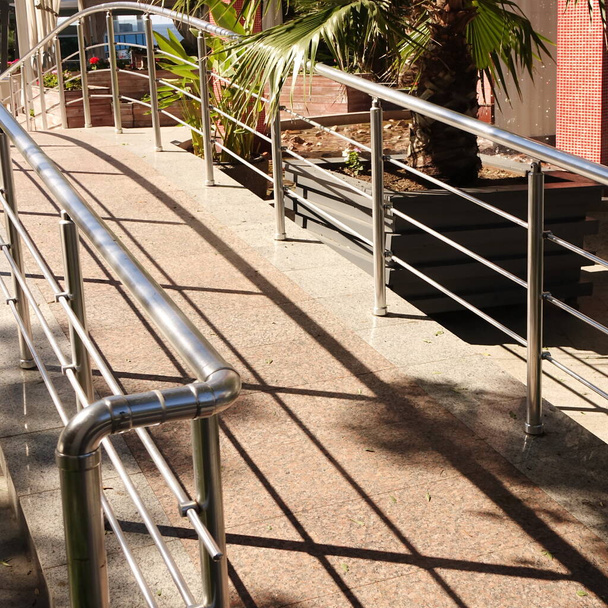 Pequeño puente peatonal decorativo con riel de acero inoxidable y piso de mármol de cola en el jardín tropical o el parque - Foto, imagen