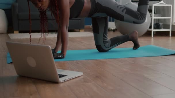 Felnőtt fekete nő ül a jóga térképen néz online fitness edzés - Felvétel, videó