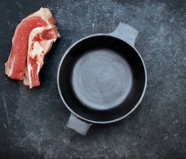 鋳鉄鍋と調理されていない生肉をキャスト.牛のブリスケットオン - 写真・画像