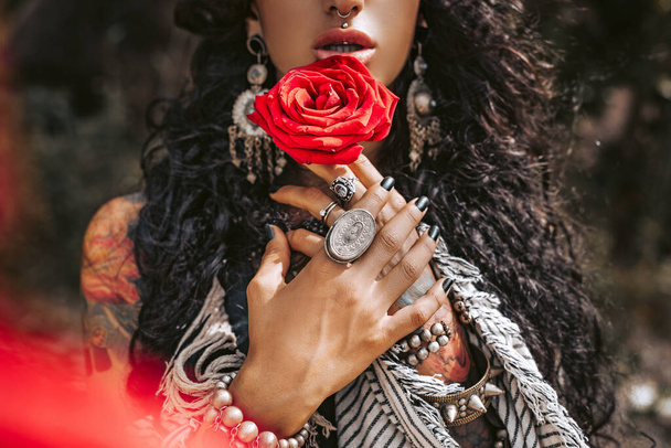 beautiful young gypsy style woman with red rose outdoors - Zdjęcie, obraz