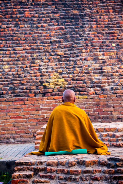 Кушинагар, Уттар-Прадеш, Індія - 21 березня 2013: буддійський монах медитує в Рамабхар-Ступі, місці кремації Лорда-Будди. Цей Ступу називають Мукут-Бандхан Чайтья. - Фото, зображення