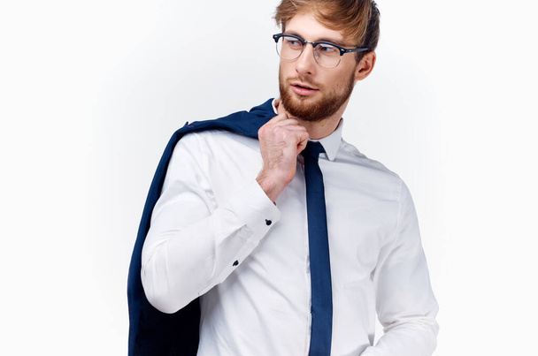  uomo in camicia e cravatta tiene una giacca sullo sfondo della spalla - Foto, immagini