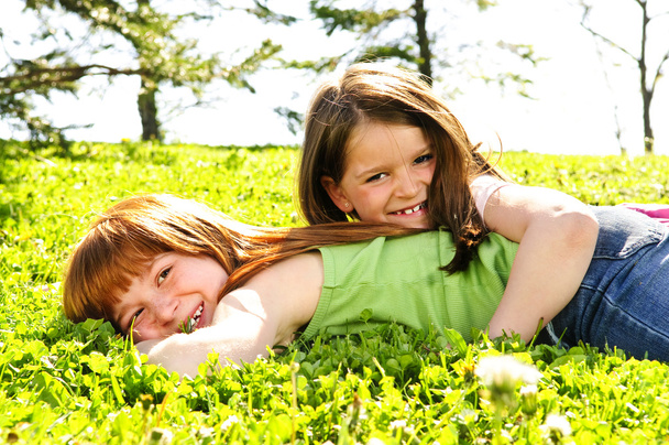 Portrait of happy girls playing on grass - 写真・画像