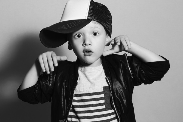 divatos kis boy.hip-hop stílus. divat children.handsome szőke gyerek, nagy kék eyes.pose fiú, kalapban nyomozó személy. fiatal rapper. vicces gyerek sapka. 4 éves - Fotó, kép