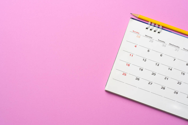 κλείσιμο του ημερολογίου στο φόντο ροζ πίνακα, σχεδιασμός για επαγγελματική συνάντηση ή ταξιδιωτικό σχεδιασμό έννοια - Φωτογραφία, εικόνα