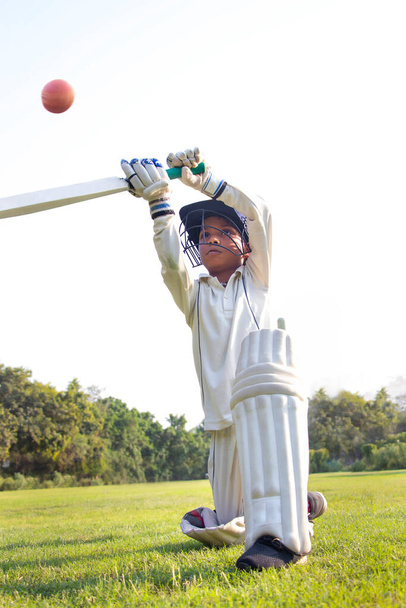 Мальчик играет в защитном костюме во время крикета - Фото, изображение