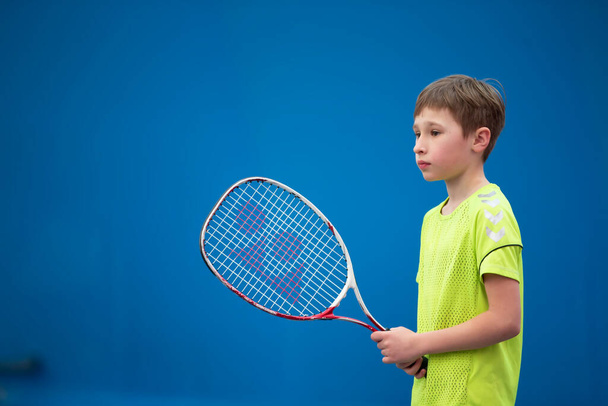 Rapazinho com uma raquete de ténis. A criança joga tênis. - Foto, Imagem