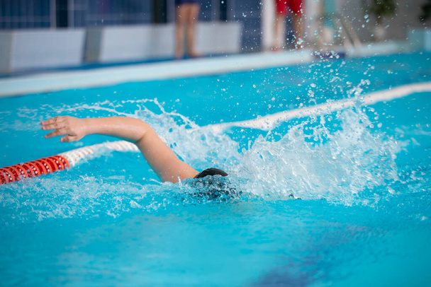 Een atleet zwemt in het sportbad. - Foto, afbeelding