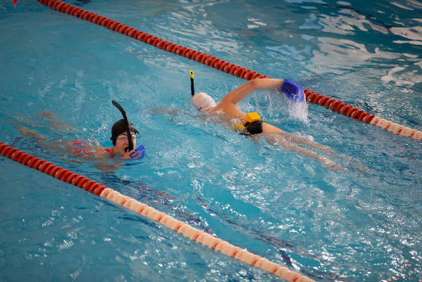 Οι αθλητές Ντίτι μαθαίνουν να κολυμπάνε στην πισίνα. - Φωτογραφία, εικόνα