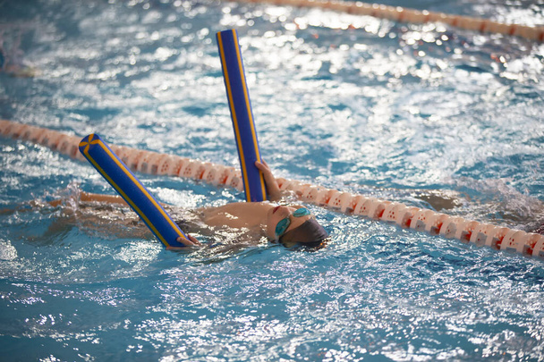 Lapsiurheilija ui altaassa. Uima-alue. - Valokuva, kuva