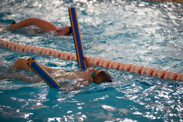 Child athlete swims in the pool. Swimming section. - Photo, Image
