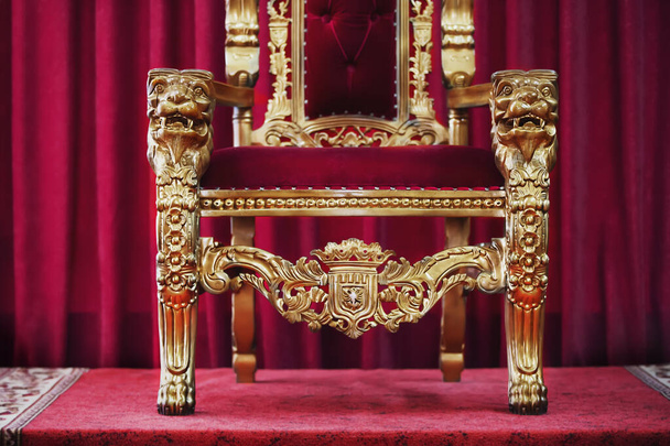 Une partie de la chaise royale rouge sur fond de rideaux rouges. Un endroit pour un roi. Trône - Photo, image
