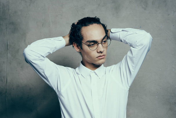 attractive young man wearing glasses white shirt straightens hair on his head portrait - Photo, Image