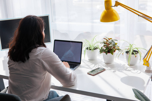 Freelancer mulher trabalhando no espaço de cópia tela branca laptop dia ensolarado remotamente - Foto, Imagem