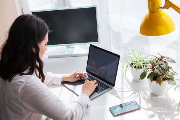 donna freelance lavorando sul computer portatile schermo bianco copia spazio giornata di sole a distanza - Foto, immagini