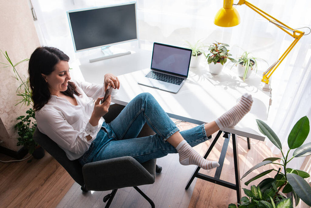 femme pigiste assis sur le lieu de travail surf internet sur le téléphone copie espace style de vie - Photo, image
