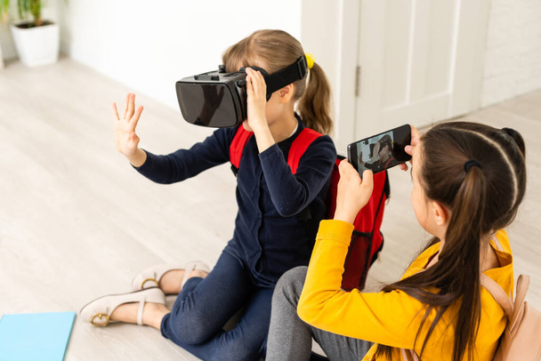 A virtuális valóságban tanulok. Modern technológia. Érdekes lecke. Virtuális tanítás. Magántanuló online. Egy lány, aki virtuális iskolában tanul. Virtuális oktatás. Gyermek aranyos tanuló viselni hmd vr szemüveg. - Fotó, kép