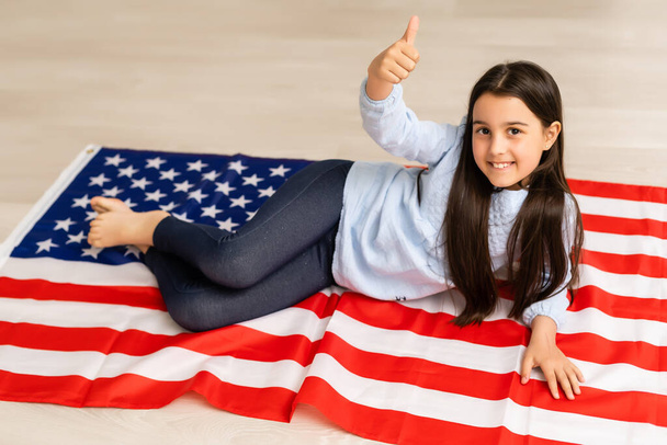 images of lovely little girl over USA flag background - Photo, Image