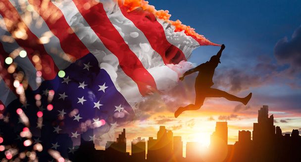 Silhouette Mann springt Griff US-amerikanische Flagge auf schönen Sonnenaufgang. Für den Gedenktag der USA, Veteranentag, Tag der Arbeit oder Feier des 4. Juli - Foto, Bild
