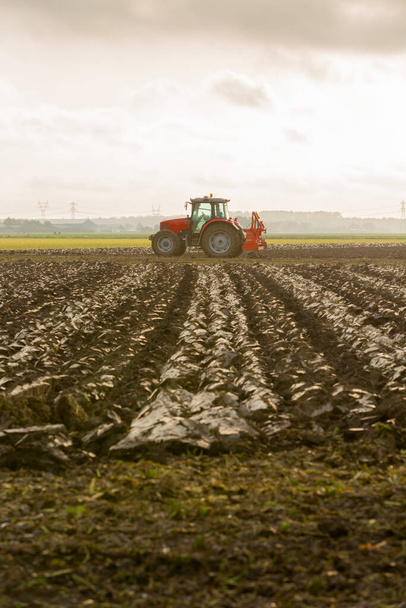 Трактори, що оранюють багатий ґрунт землі
 - Фото, зображення