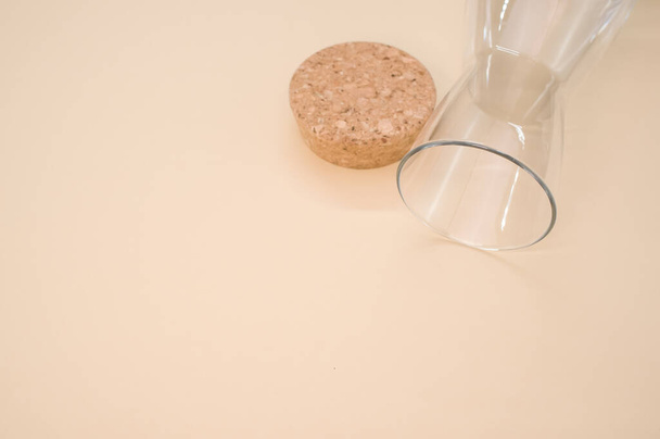 A closeup shot of an empty glass with a cork cover isolated on a pink background with copyscape - Foto, Bild