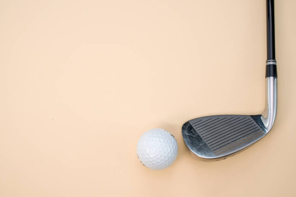 A closeup shot of a golf ball and a club isolated on a pink background - Photo, Image
