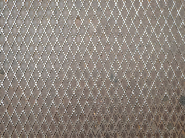 Kovová deska s trojúhelníkovou texturou na podlaze města - Fotografie, Obrázek