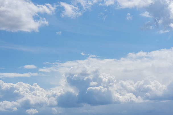 Een natuurlijk uitzicht op katoenachtige wolken in de blauwe lucht met copyspace - Foto, afbeelding