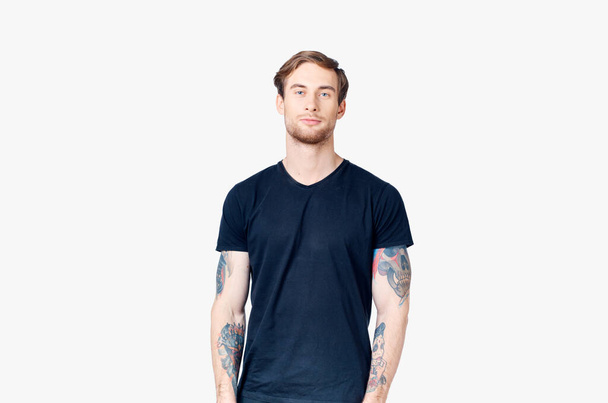 retrato de un hombre guapo en una camiseta azul modelo de primer plano tatuaje - Foto, imagen