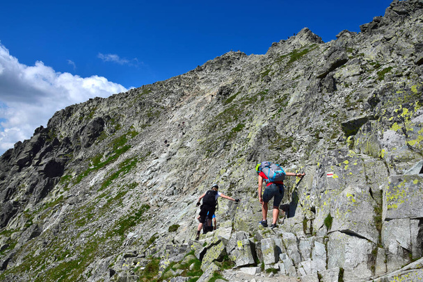 Hikers climbing up to the summit of mount Rysy, one of the highest mountains of the High Tatras. Slovakia, Poland. - Photo, Image