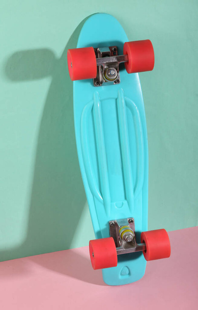 Penny board on blue-pink background. Minimalism. Trendy shadow. Creative layout. - Photo, Image