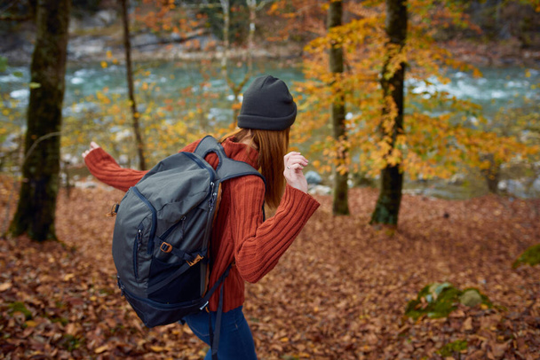 nő hátizsák utazás turizmus erdő táj park folyó lehullott levelek oldalnézet - Fotó, kép