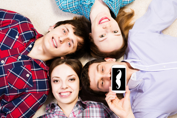 Четверо молодых людей лежат вместе
 - Фото, изображение
