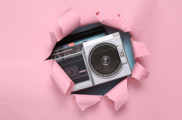 Retro-Boombox-Audioplayer auf rosa Hintergrund mit zerrissenem Papier. Konzeptkunst. Pastellfarbentrend. Kreatives Layout. Minimalismus. Ansicht von oben - Foto, Bild