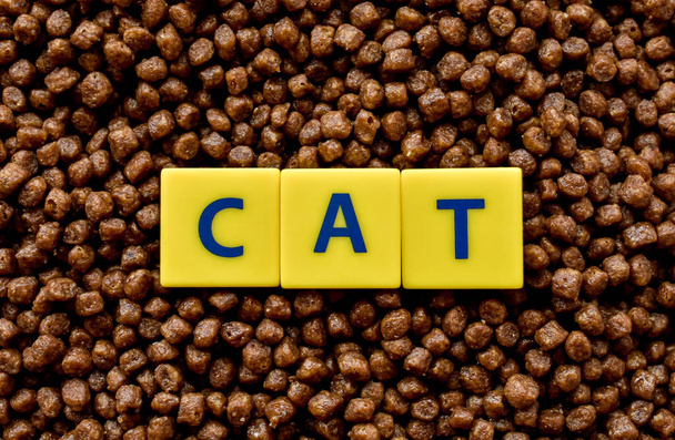 Dry food for animals with the word cat from letters. Close-up, texture. - Photo, image