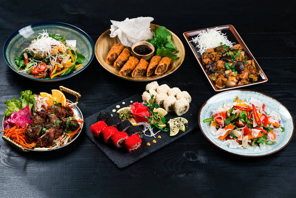 asian food assorted set on the table, Wok, noodles and vegetables salad and chopsticks on dark rustic background. Chinese dishes, Asian style - Foto, Imagem