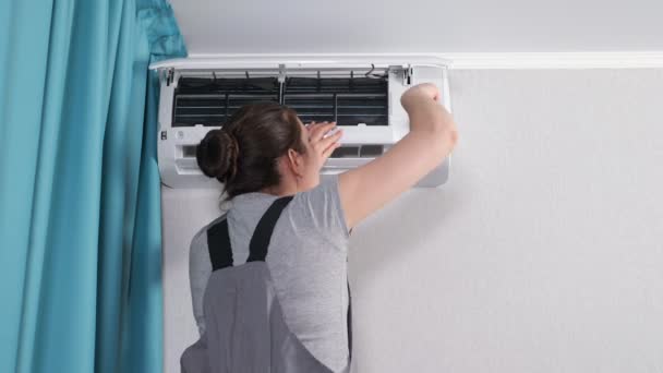 Woman tightens screw with screwdriver on air conditioner - Footage, Video