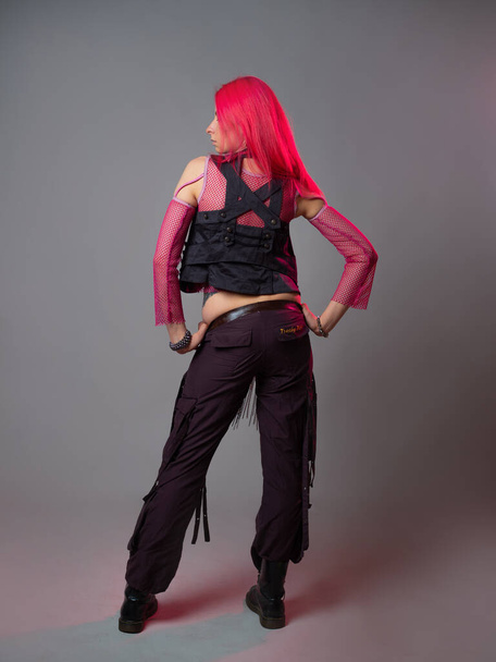 Futuristic fashion, a young bright and attractive woman with pink hair, - Foto, Imagen