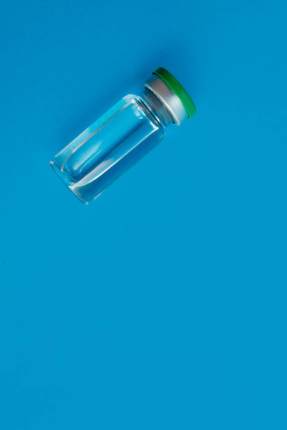 ampolla con medicamento sobre fondo azul - Foto, Imagen