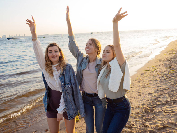 Three friends are walking on the beach, the happiness of communication. - Φωτογραφία, εικόνα