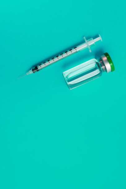緑色の背景に薬と注射器のアンプル - 写真・画像