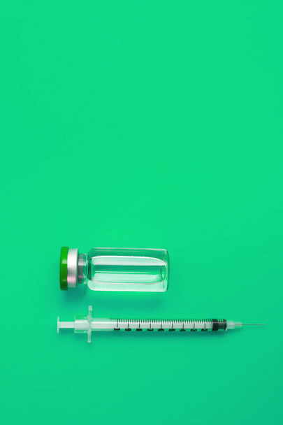 syringe ampoule with medicine on green background - Foto, immagini