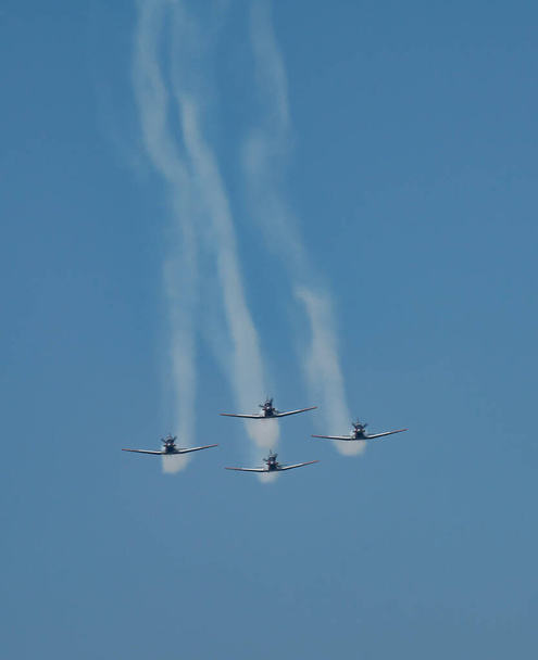 Группа из четырех пилотов, выполняющих маневр на авиашоу. - Фото, изображение