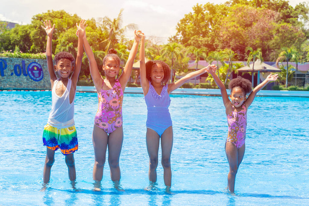 grupo de niños negros felices jugando al parque de la piscina de agua al aire libre en la temporada de verano caliente - Foto, Imagen